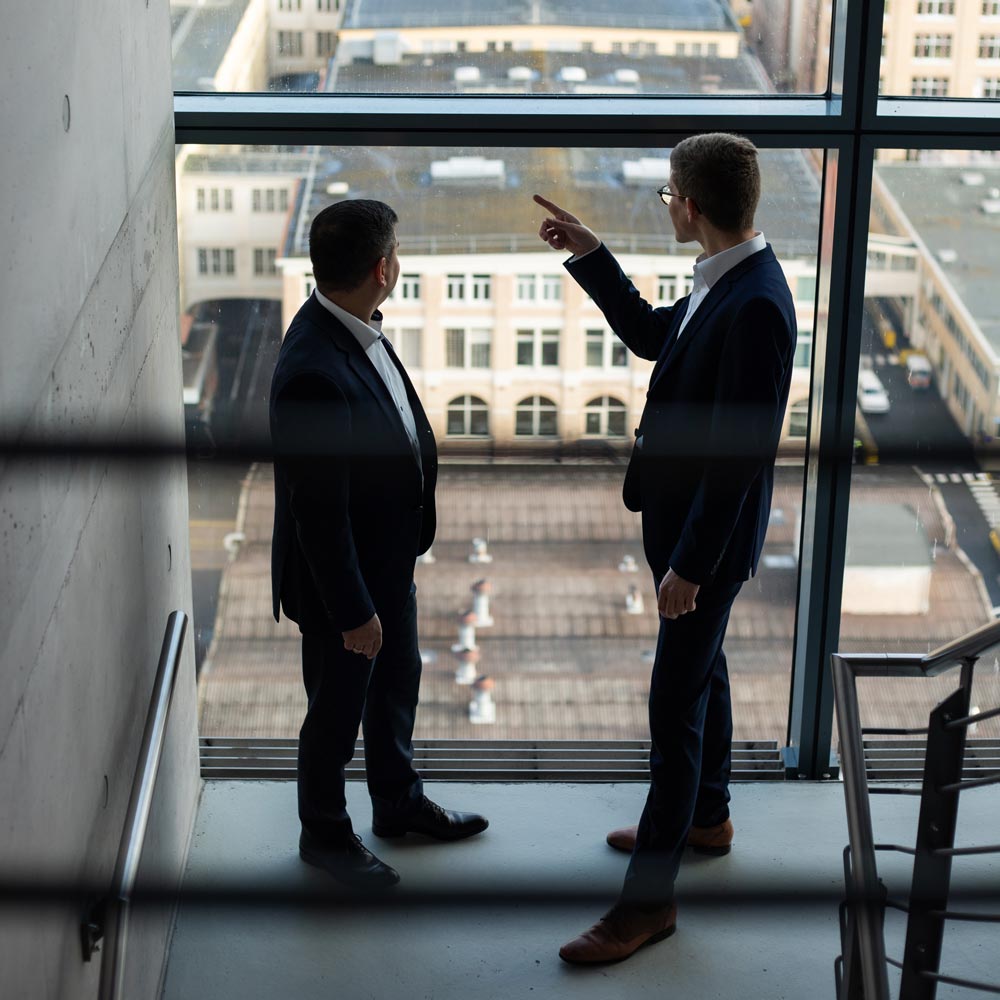 Sven Hepting und Sascha Mark im Treppenhaus aus dem Fenster schauend